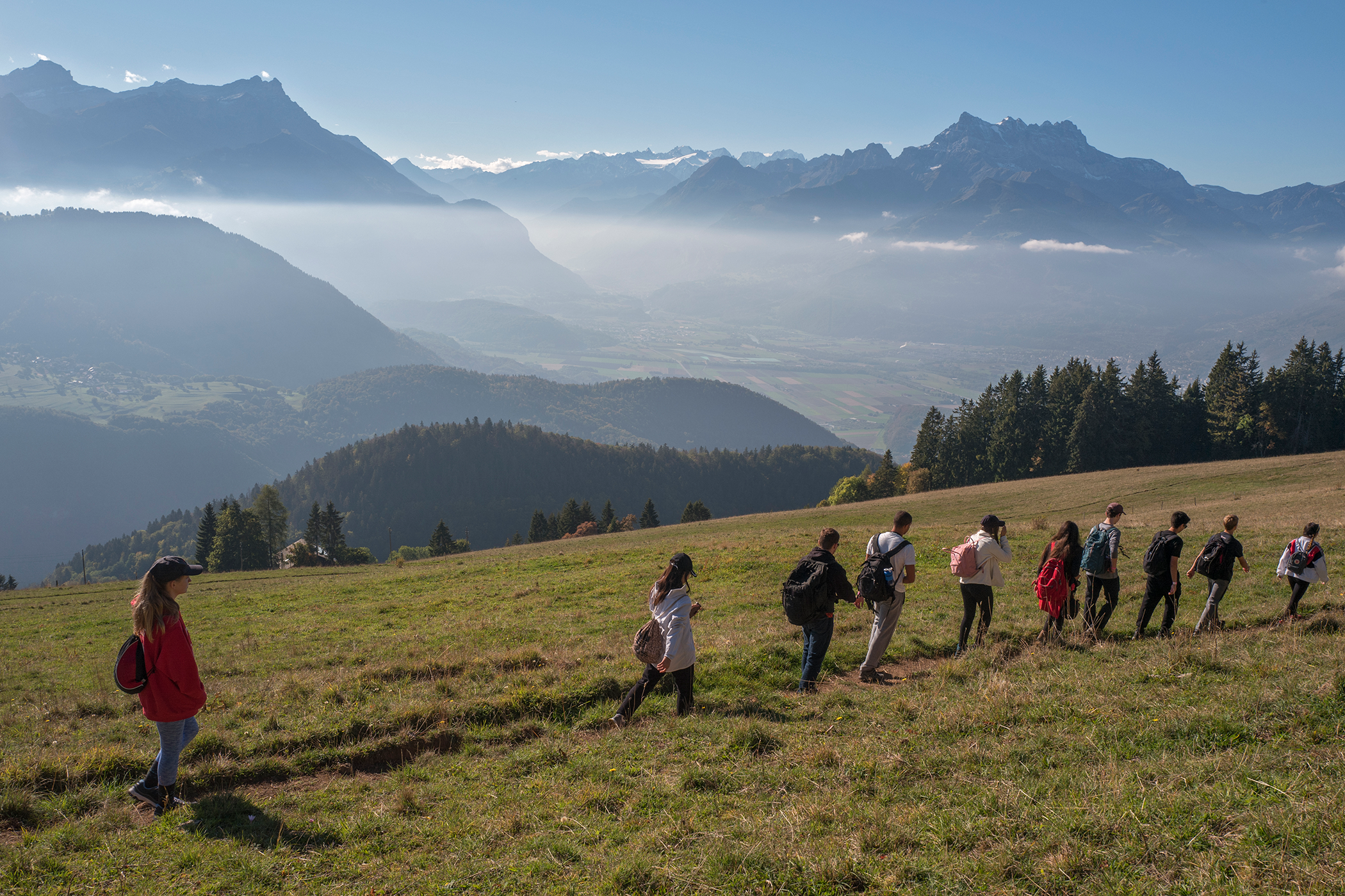 Ten children hiking on the Swiss Alps during a summer camp