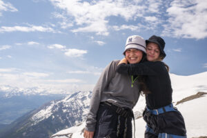 Happy hikers hugging on snowy alpine ridge