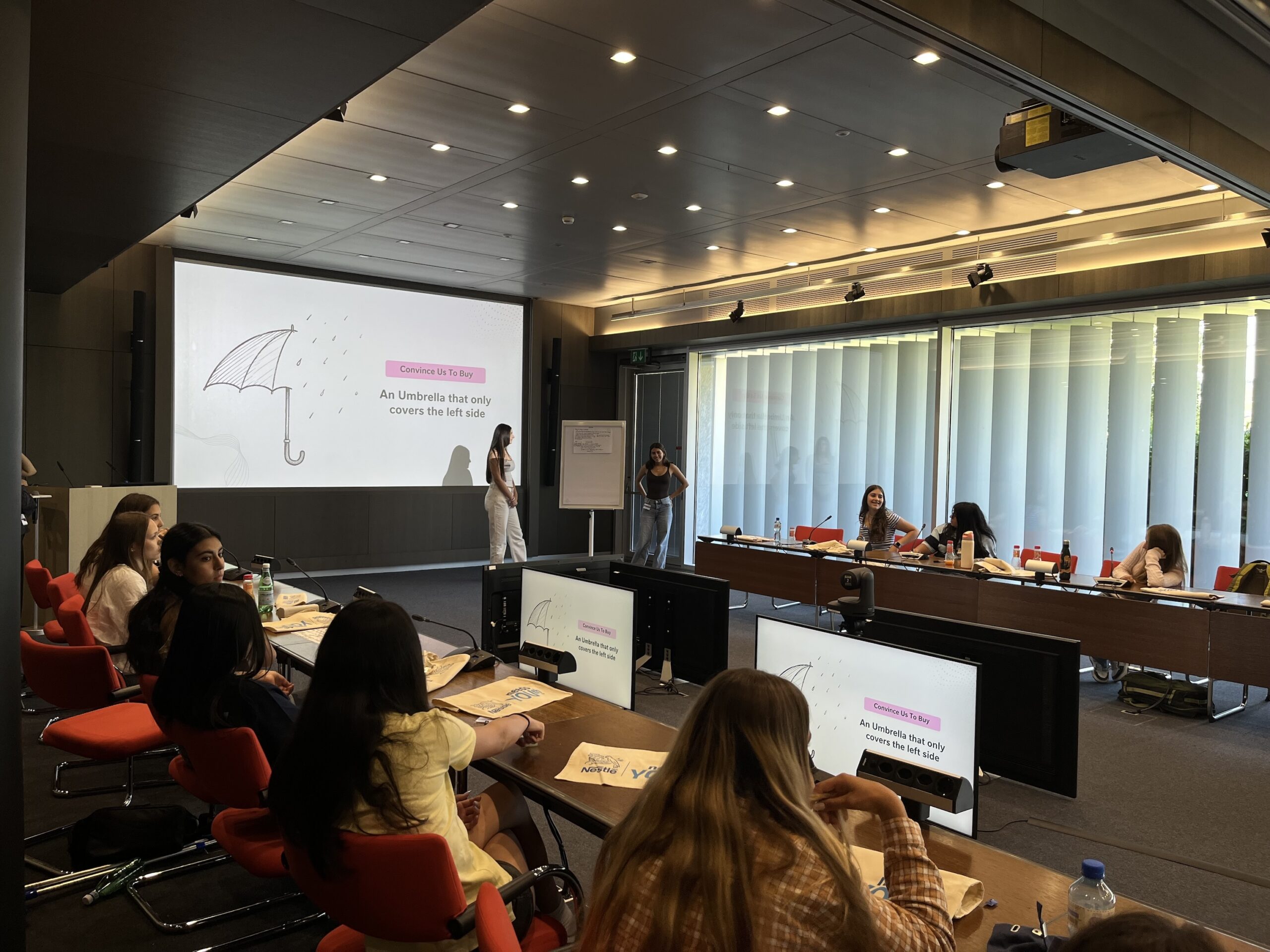 Team pitch during innovation workshop in a modern conference room with projector screens